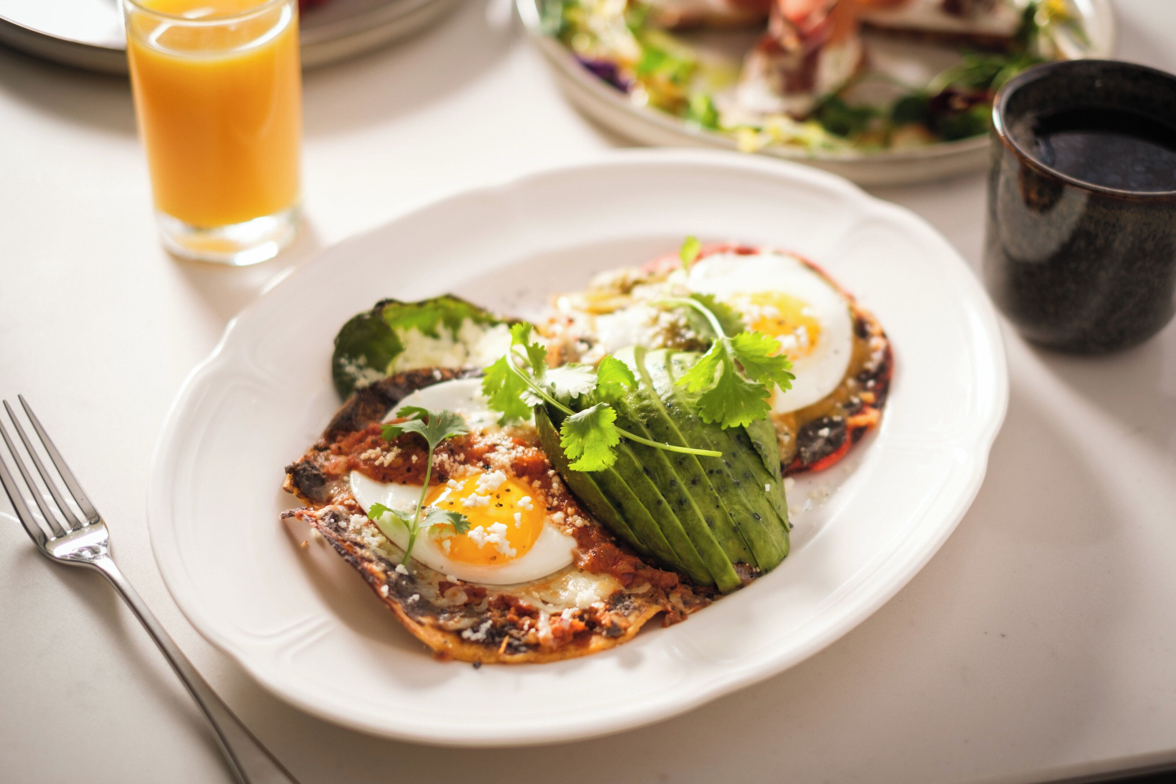 A plate of food with eggs, greens, and a slice of bread.