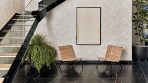 A modern interior with a staircase, two wooden chairs, a large framed artwork, and a potted plant. - Kimpton El Castelar Polanco by IHG (Mexico City)