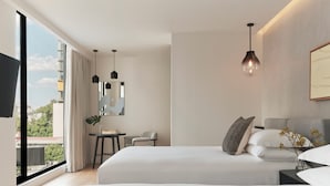 A modern hotel room with a large bed, a desk, a chair, and a view of the city. - Kimpton El Castelar Polanco by IHG (Mexico City)