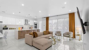 Ein modernes Wohnzimmer mit einer Couch, einem Couchtisch und einem Fernseher.