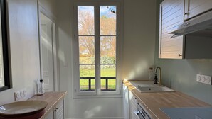 Eine moderne Küche mit großem Fenster, einer Spüle und einem Herd.