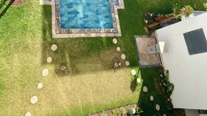 A rooftop pool with a surrounding garden, a small deck, and a building with balconies. - Luxurious apartment 5 min from Mohamed 5 airport (Casablanca)