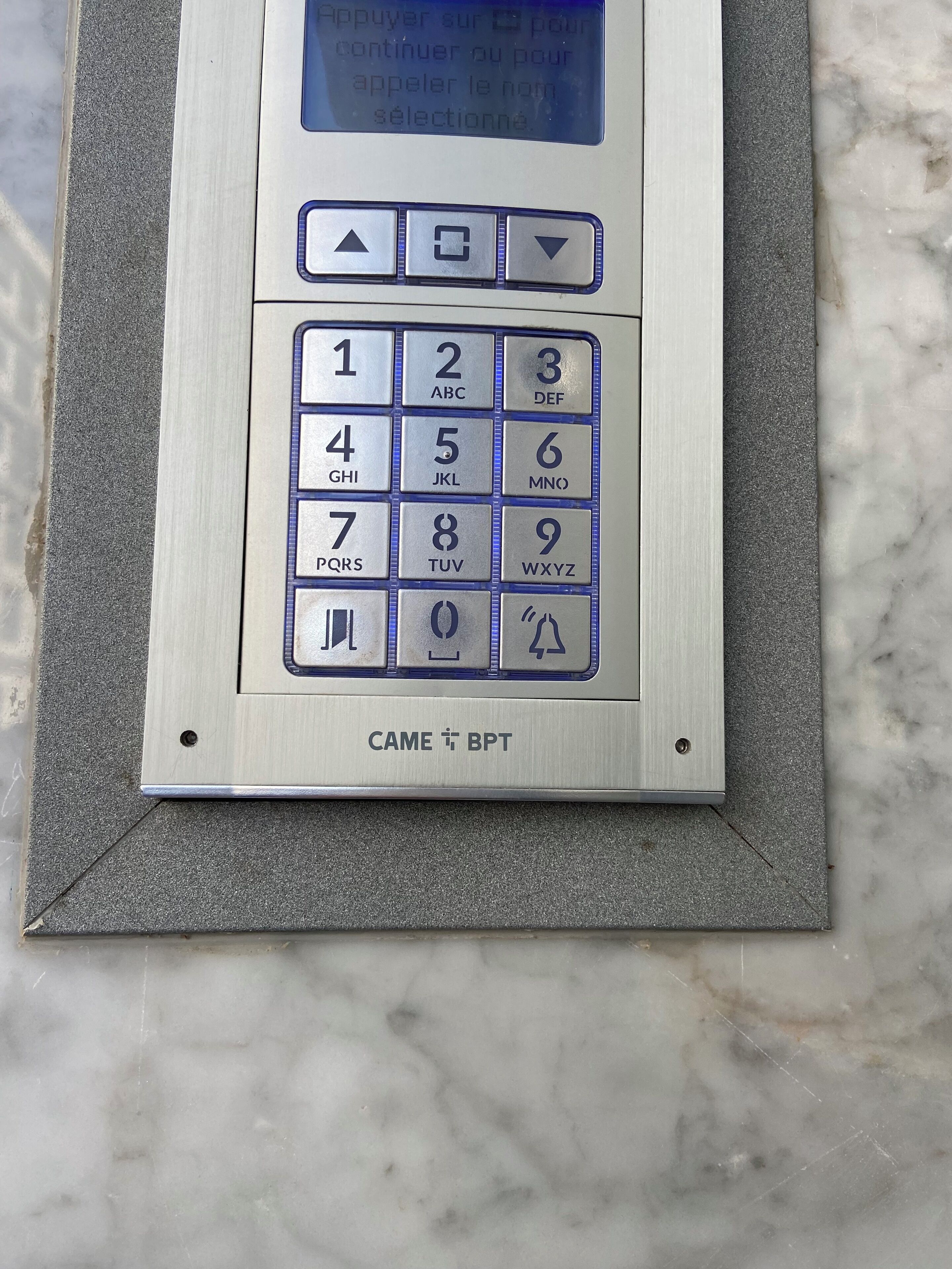 Ein Tastenfeld mit Zahlen und Buchstaben, ein Navigationsfeld sowie ein Schild mit der Aufschrift 'CAME BPT'.
