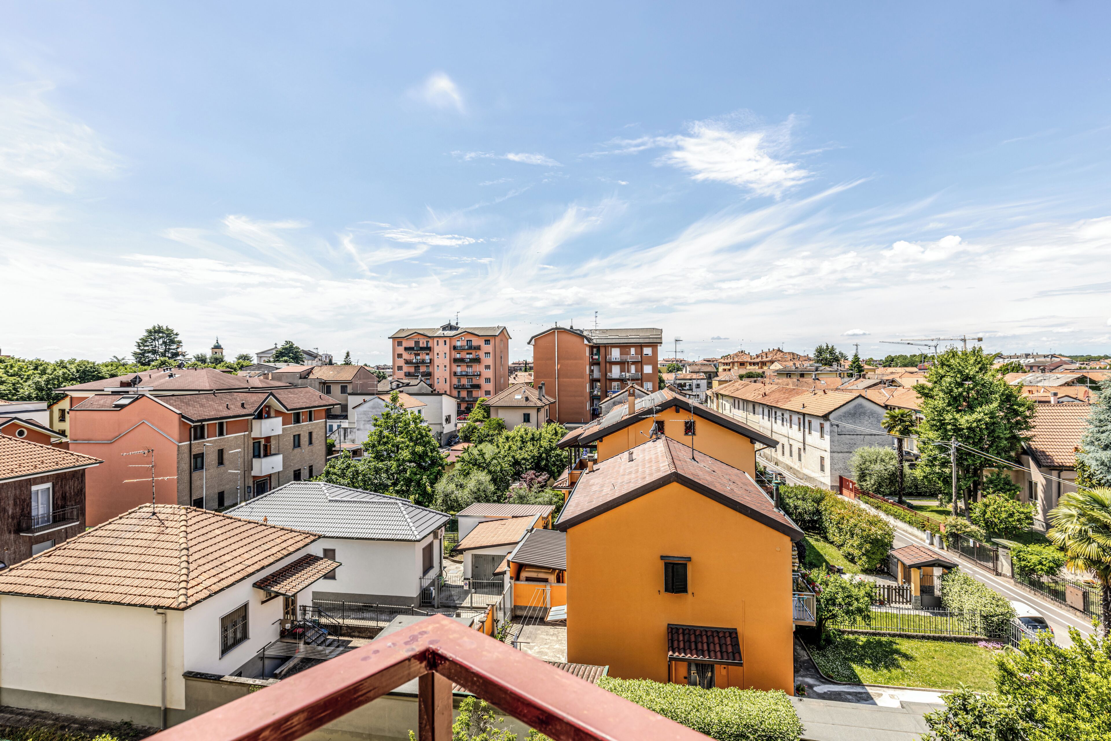 A residential area with various buildings, including a prominent yellow house with a balcony.
