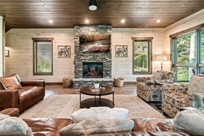 Un salon chaleureux avec une cheminée en pierre, des murs en bois et des sièges confortables.