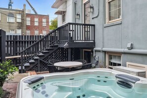 A hot tub with a wooden deck, a staircase, and a table with chairs. - Preserved 1800s 3BR Home, Downtown Savannah (Savannah)