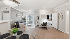 A modern living room with a sofa, coffee table, and dining area. - Modern Dallas Stay Near Love Field and Pool (Dallas)