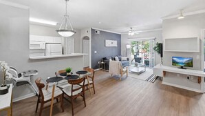 Un apartamento moderno con comedor, cocina, sala de estar y balcón.