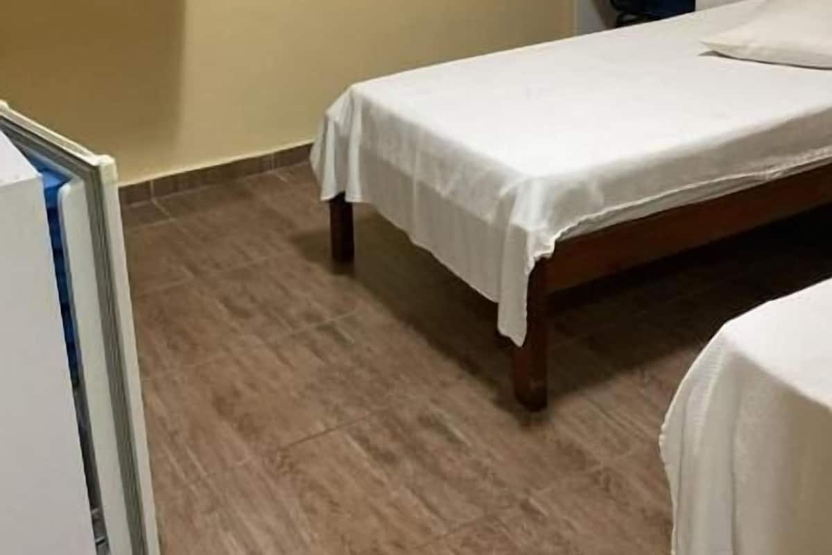 A bedroom with a bed, a desk, a chair, and a wardrobe.
