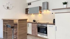 A modern kitchen with a built-in oven, a microwave, and a stainless steel sink. - Apartament Agnes by Q4 Apartments  (Gdańsk)