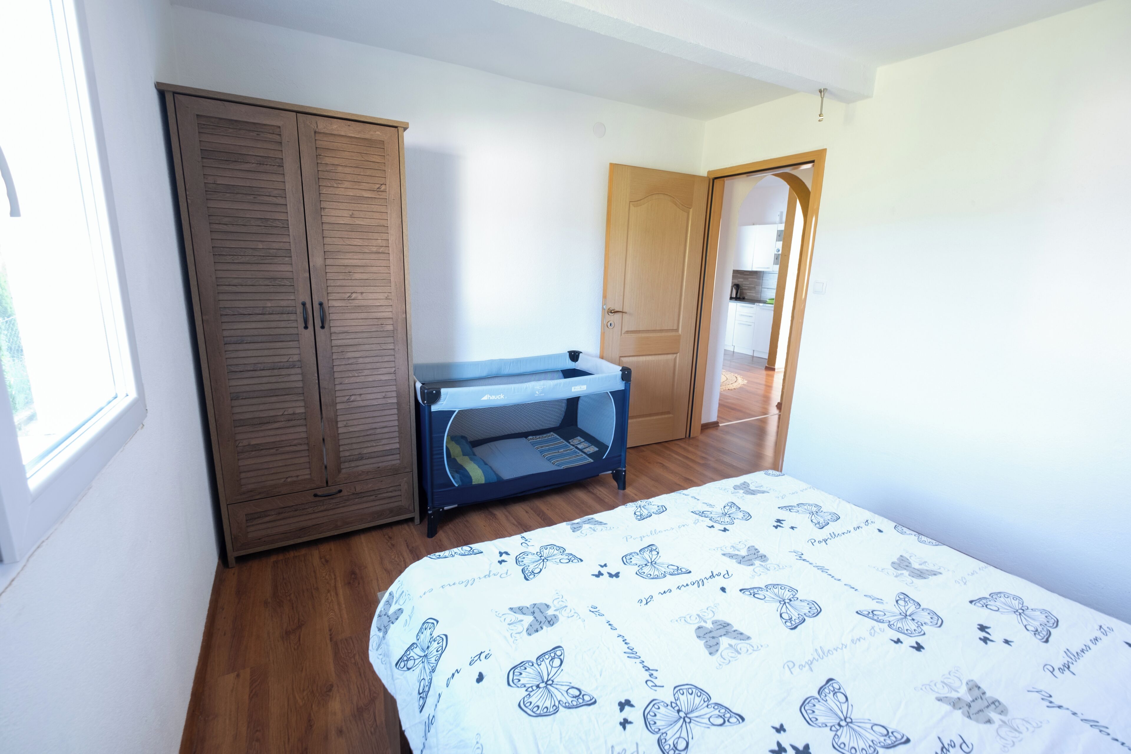 A bedroom with a bed, wardrobe, and desk.