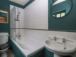 A bathroom with a bathtub, a sink, and a toilet. - The Cooks Cottage (Malton)