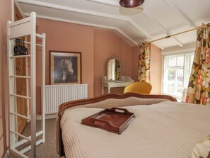 Une chambre avec un lit superposé, une échelle, un tableau représentant un cheval encadré, un bureau avec un miroir et une fenêtre avec des rideaux.