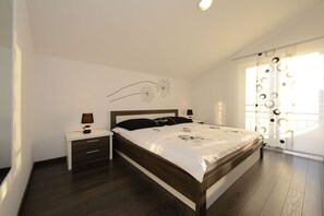 Ein Schlafzimmer mit einem Bett, einem Nachttisch, einer Lampe und einer Wanddekoration.