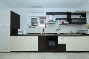 Eine moderne Küche mit Geschirrspüler, Backofen und einem Fenster mit Jalousien.