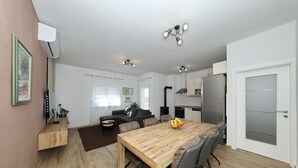 Una cocina moderna con una mesa de comedor de madera, sillas grises y un horno empotrado.