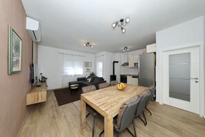 Eine moderne Küche mit einem Holzespeisetisch, grauen Stühlen und einem eingebauten Backofen.