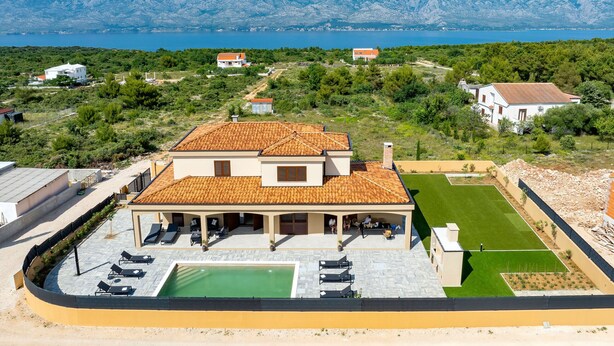 A villa with a swimming pool, outdoor seating, and a view of the sea and mountains. - Holiday Home Pecora Nera with Pool (Ražanac)