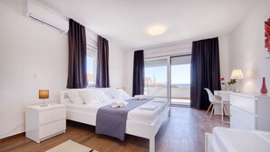 Ett modernt hotellrum med en säng, sängbord, ett skrivbord och utsikt över staden.