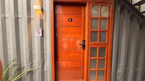 A wooden door with a glass panel and a 'PROHIBIDO FUMAR' sign. - Loft127-04 Compact, equipped, great location (Itajaí)