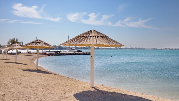 A beach with umbrellas and a clear view of the water. - Apartment Perinic No.1 in Vrsi (Vrsi)
