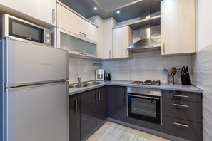A modern kitchen with stainless steel appliances, wooden cabinets, and a built-in oven. - Holiday Home Ana Maria by the Beach (Vir)