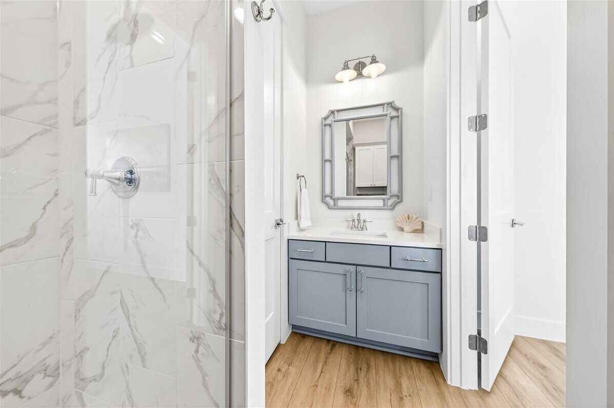 A bathroom with a shower, a sink, and a mirror.