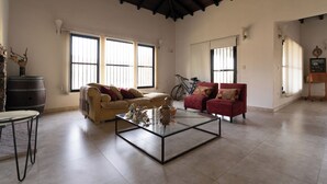 A spacious living room with a high ceiling, large windows, a glass coffee table, and two sofas. - Casa Andina: Rustic Warmth, Fire Corner and Total Relaxation in Chacras (Luján de Cuyo)