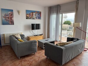 Ein Wohnzimmer mit einer Couch, einem Couchtisch, einem Fernseher und Kunstwerken an der Wand.