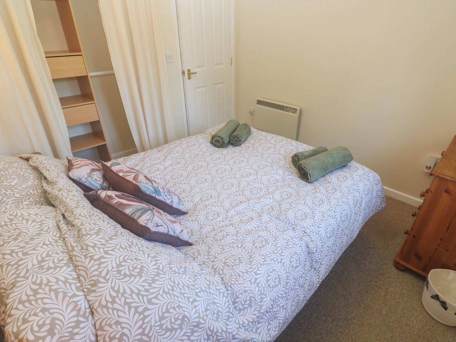 Un dormitorio con cama, armario y radiador.