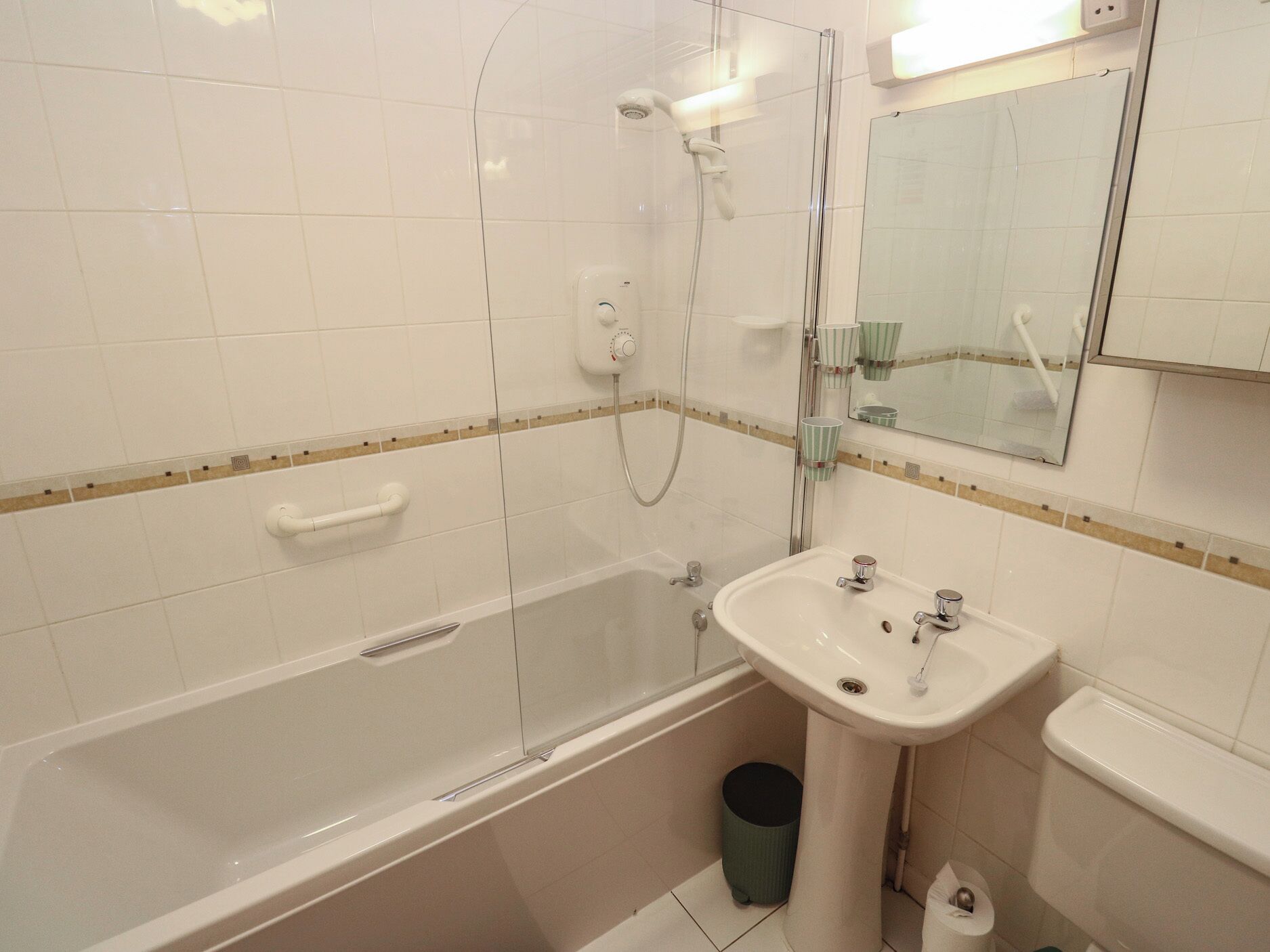 A bathroom with a bathtub, a sink, a mirror, and a shower.