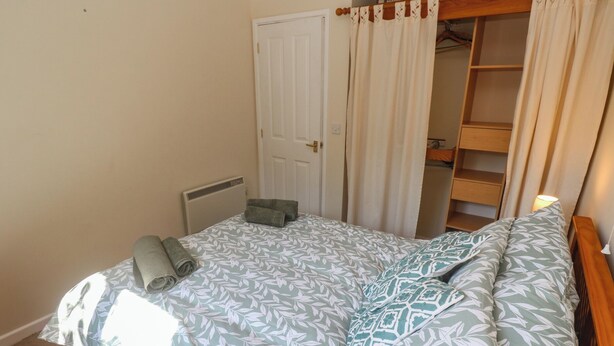 Un dormitorio con cama, armario y radiador.