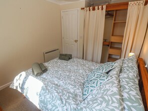 Un dormitorio con cama, armario y radiador.