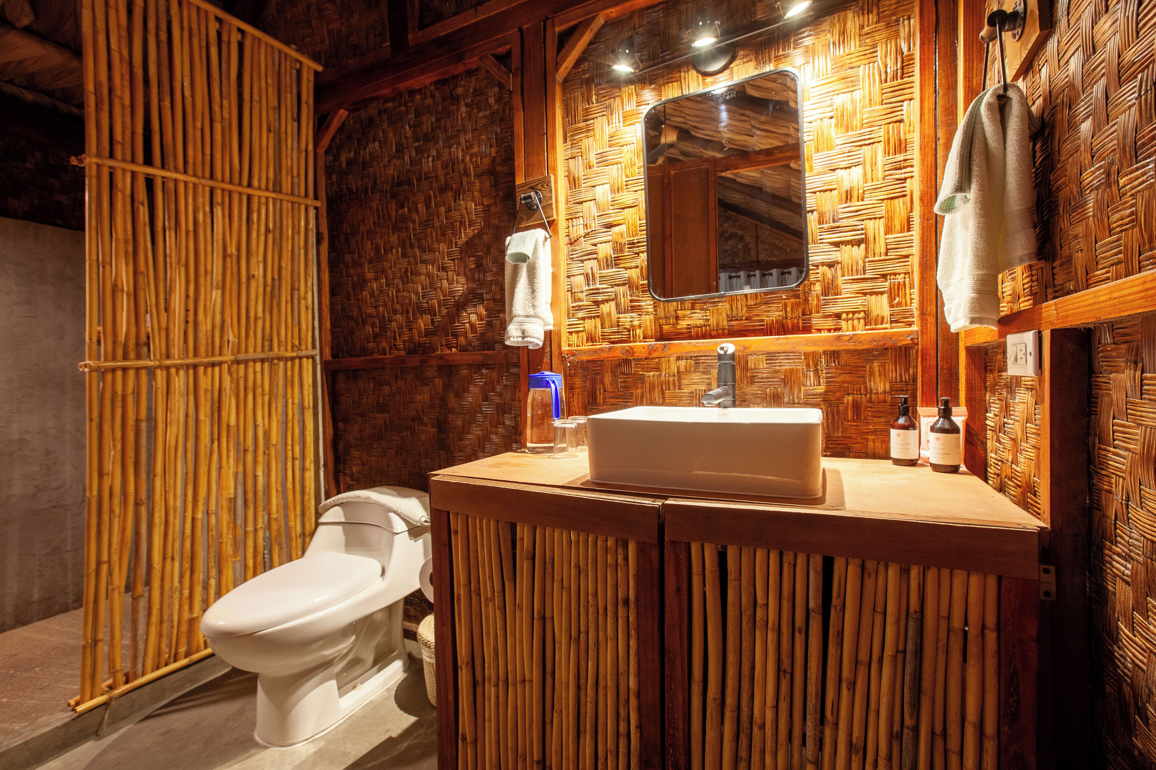 Ein Badezimmer mit Holzwand, Waschbecken in Weiß und Toilette.