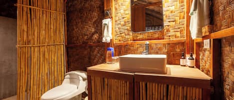 Ein Badezimmer mit Holzwand, Waschbecken in Weiß und Toilette.