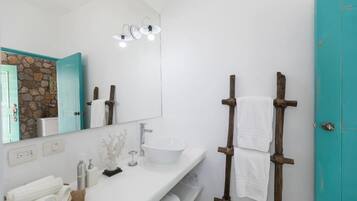 Ein Badezimmer mit einem weißen Waschbecken, einem Spiegel und einem Handtuchhalter.