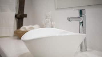 A white ceramic sink with a modern faucet on a white countertop.