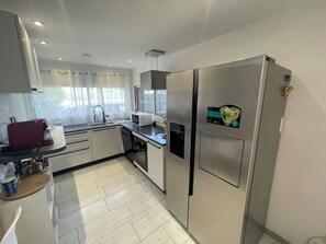 Eine moderne Küche mit Edelstahlgeräten, einer Mikrowelle und einem Kühlschrank.