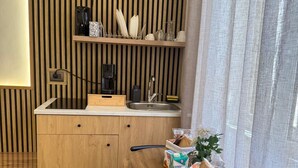 A compact kitchen with a wooden countertop, a sink, and a dining area with a table and chairs. - Anthony Emanuele Fuoco (Torre del Greco)