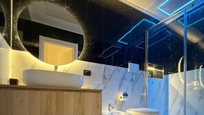 A modern bathroom with a large mirror, a white sink, a bidet, and a toilet. - Anthony Emanuele Fuoco (Torre del Greco)