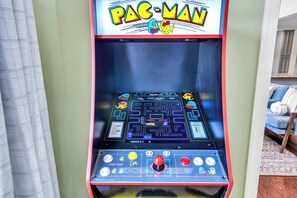 A Pac-Man arcade machine with a maze game, score display, and control buttons.