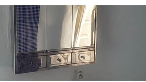Kylpyhuoneessa on peili, pesuallas ja pyyheteline.