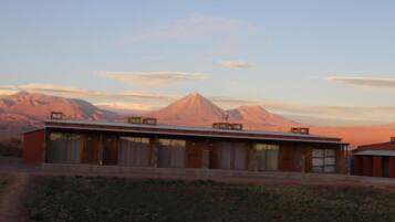 A building with a long, flat roof, multiple windows, and a simple, rectangular structure.