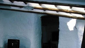 Un edificio con facciata bianca, struttura in travi di legno e un'apertura ad arco scura.