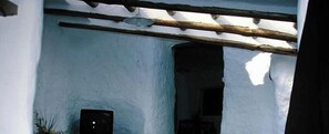 A building with a white exterior, a wooden beam structure, and a dark door.