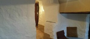 A narrow hallway with white walls and a wooden door.