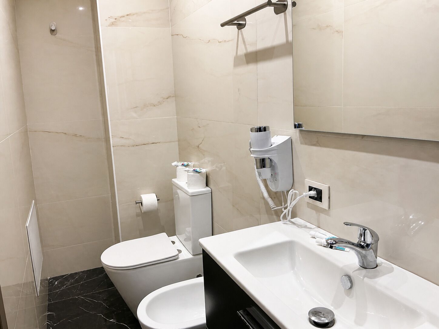 A modern bathroom with a toilet, bidet, and sink.