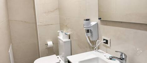 A modern bathroom with a toilet, bidet, and sink.