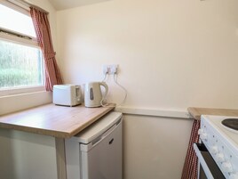 A compact kitchen with a toaster, kettle, and a small dishwasher.