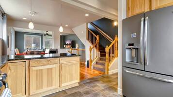 A modern kitchen with wooden cabinets, a stainless steel refrigerator, and a built-in oven.